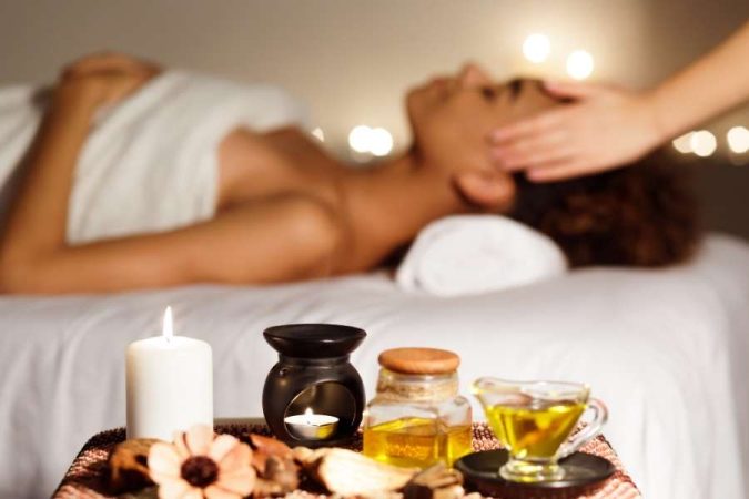 Relaxing massage therapy session with candles and essential oils in a spa setting